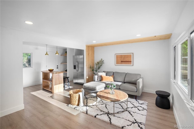 living area with recessed lighting, baseboards, and wood finished floors