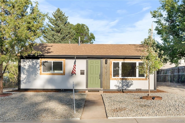 ranch-style house with roof with shingles and fence