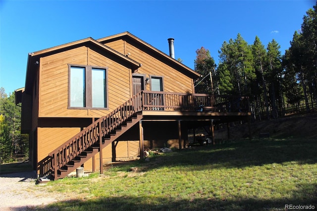 rear view of house featuring a lawn and a deck