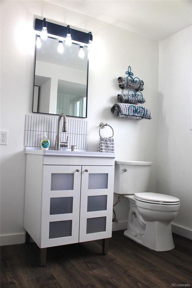 bathroom featuring vanity, hardwood / wood-style flooring, and toilet