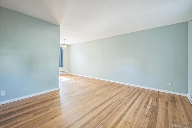 2858 Jasmine St, Denver, CO 80207 - empty room featuring light wood-style floors, baseboard heating, and baseboards