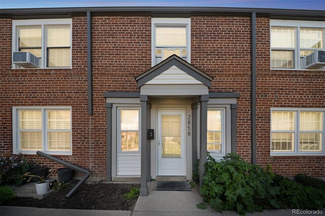 2858 Jasmine St, Denver, CO 80207 - doorway to property with brick siding and cooling unit