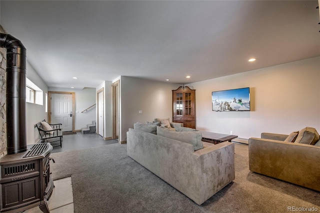 living room featuring stairway, light colored carpet, a wood stove, and recessed lighting