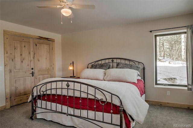 carpeted bedroom with ceiling fan and baseboards