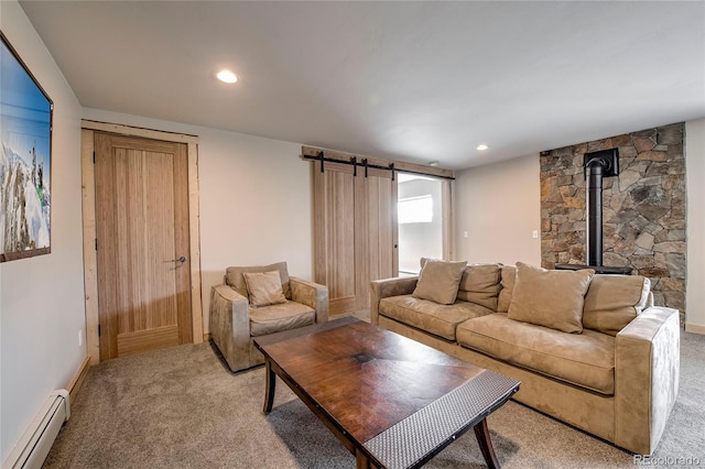 living area featuring light carpet, a barn door, a baseboard radiator, a wood stove, and recessed lighting