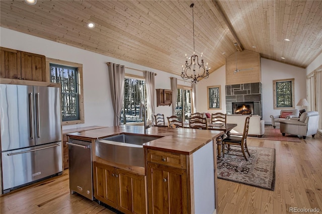 kitchen featuring wooden ceiling, wood counters, open floor plan, appliances with stainless steel finishes, and light wood finished floors