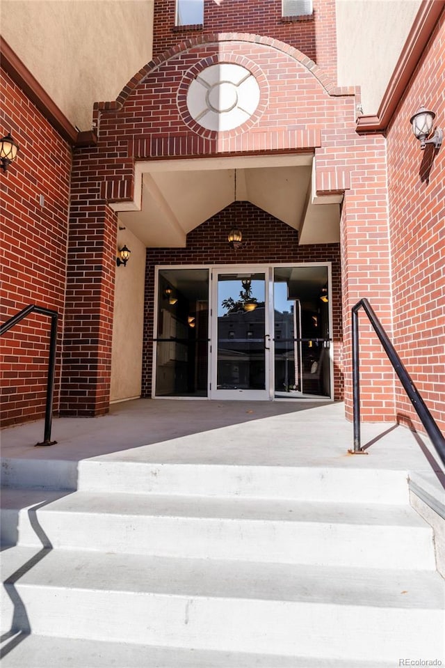 view of exterior entry featuring brick siding