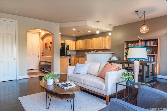 living room with arched walkways, recessed lighting, dark wood finished floors, and baseboards