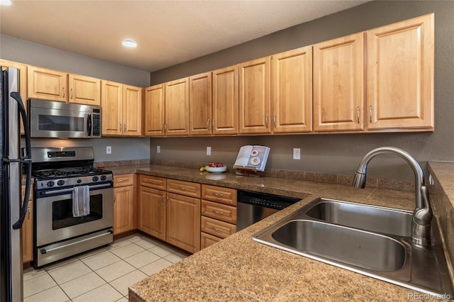 kitchen with a sink, stainless steel appliances, light brown cabinets, and light tile patterned floors