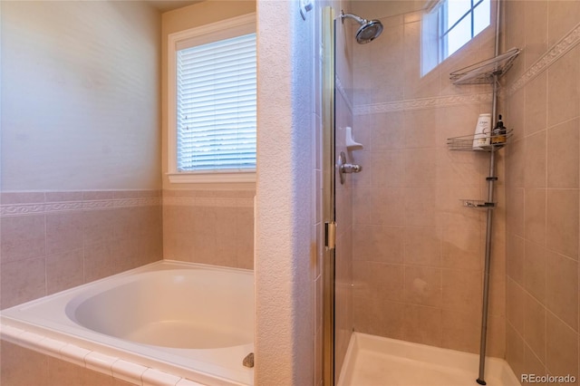 full bathroom with a wealth of natural light, a bath, and a shower stall