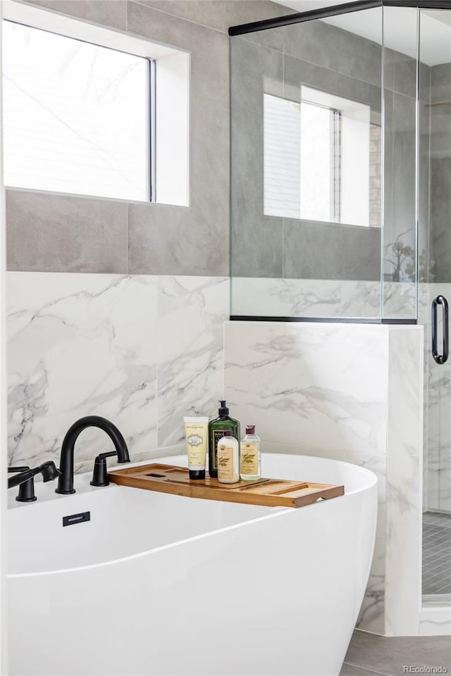 425 S Pearl St, Denver, CO 80209 - bathroom with a shower stall, a freestanding bath, and tile walls