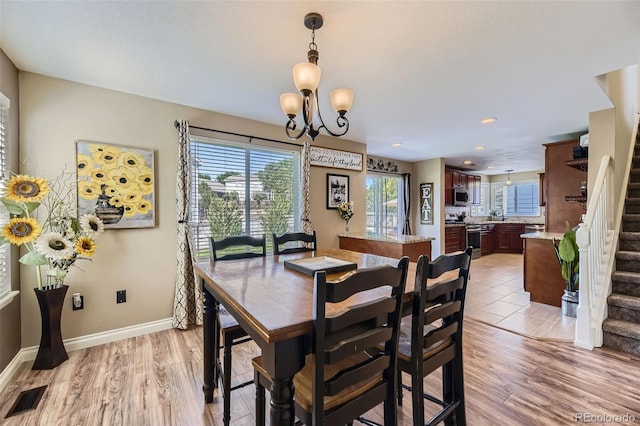 5090 Miriam Ln, Parker, CO 80134 - dining room with stairs, plenty of natural light, a chandelier, and light wood finished floors