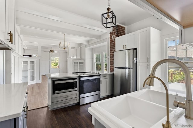 7801 Valley View St, Louviers, CO 80131 - kitchen with stainless steel appliances, dark wood-style floors, light countertops, plenty of natural light, and beamed ceiling
