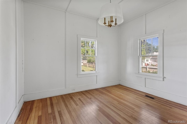 7801 Valley View St, Louviers, CO 80131 - spare room with healthy amount of natural light, light wood-style floors, and a chandelier