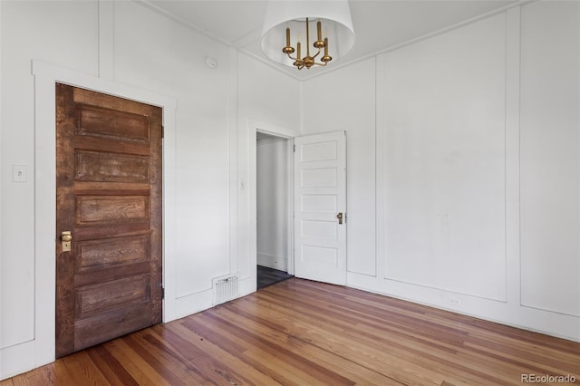 7801 Valley View St, Louviers, CO 80131 - unfurnished room with wood finished floors and a chandelier