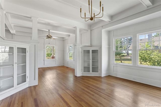 7801 Valley View St, Louviers, CO 80131 - unfurnished living room featuring a chandelier, plenty of natural light, wood-type flooring, beam ceiling, and ceiling fan