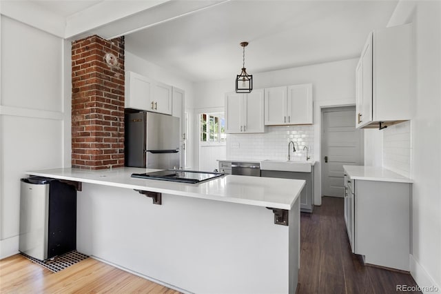 7801 Valley View St, Louviers, CO 80131 - kitchen with stainless steel appliances, a peninsula, backsplash, dark wood-style flooring, and a breakfast bar area