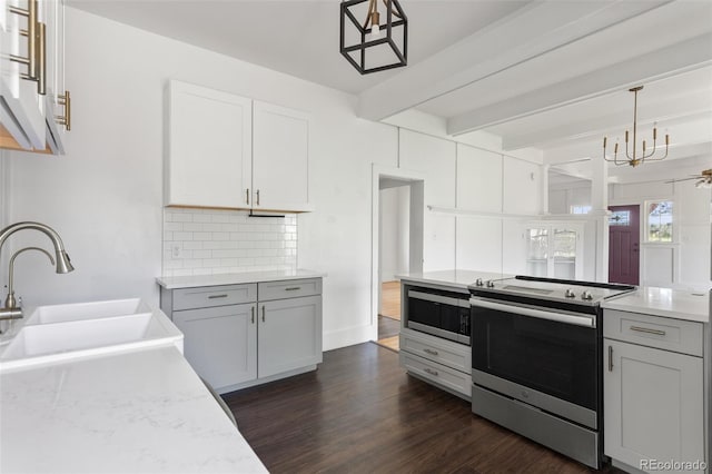 7801 Valley View St, Louviers, CO 80131 - kitchen featuring stainless steel appliances, backsplash, beam ceiling, dark wood-style floors, and decorative light fixtures