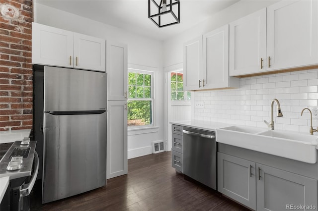 7801 Valley View St, Louviers, CO 80131 - kitchen with stainless steel appliances, backsplash, dark wood finished floors, gray cabinetry, and light countertops