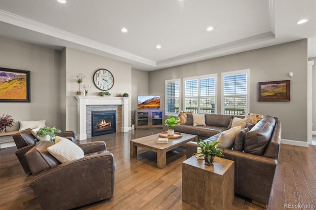 7797 S Valleyhead Way, Aurora, CO 80016 - living room with a tray ceiling, recessed lighting, baseboards, wood finished floors, and a tile fireplace