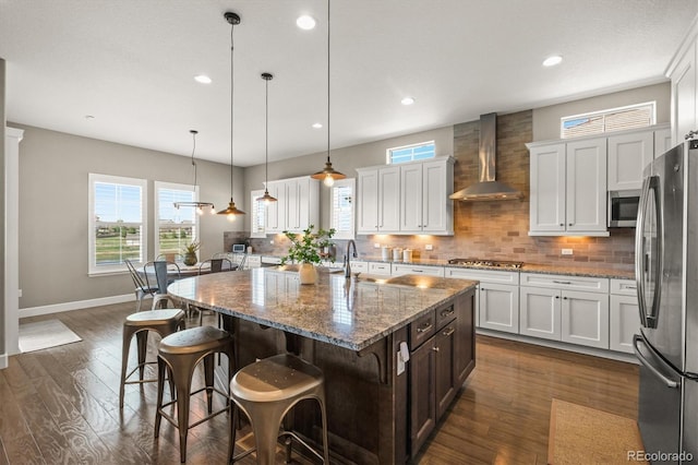 7797 S Valleyhead Way, Aurora, CO 80016 - kitchen featuring stainless steel appliances, a wealth of natural light, decorative backsplash, and wall chimney exhaust hood