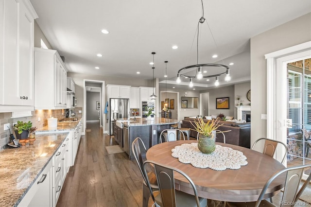 7797 S Valleyhead Way, Aurora, CO 80016 - dining space featuring a fireplace, baseboards, dark wood-style floors, and recessed lighting