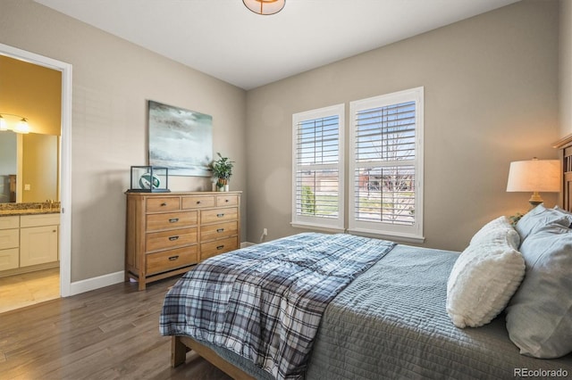 7797 S Valleyhead Way, Aurora, CO 80016 - bedroom featuring connected bathroom, wood finished floors, and baseboards