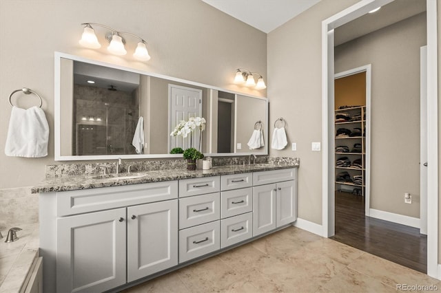 7797 S Valleyhead Way, Aurora, CO 80016 - full bath featuring a shower stall, double vanity, a sink, and a walk in closet