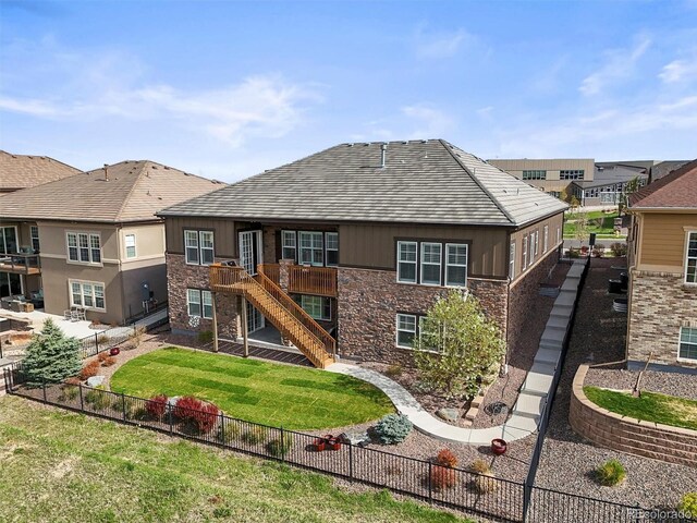 7797 S Valleyhead Way, Aurora, CO 80016 - rear view of house with a fenced backyard, stairs, a yard, and stone siding