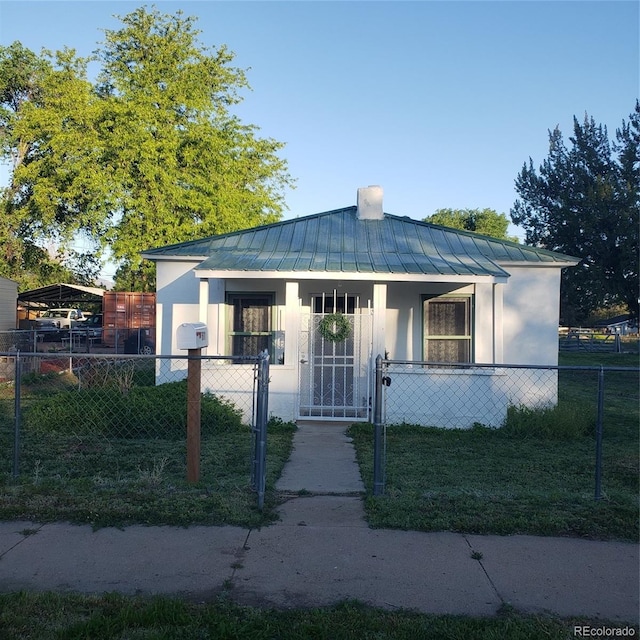 511 N Petroleum Ave, Florence, CO 81226 - bungalow-style home with a standing seam roof, stucco siding, a fenced front yard, metal roof, and a gate