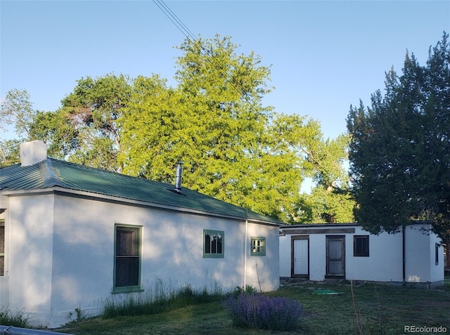 511 N Petroleum Ave, Florence, CO 81226 - back of property featuring stucco siding, metal roof, and a yard