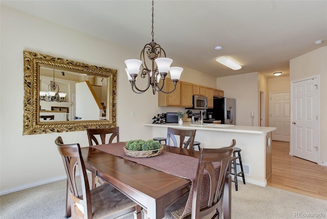 dining space featuring visible vents, light colored carpet, a notable chandelier, and baseboards
