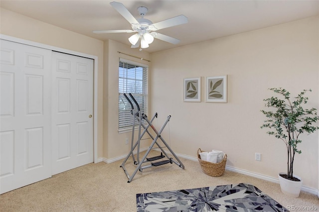 workout area featuring baseboards, a ceiling fan, and carpet flooring