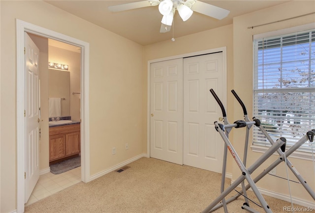 workout area with light colored carpet, baseboards, a ceiling fan, and visible vents