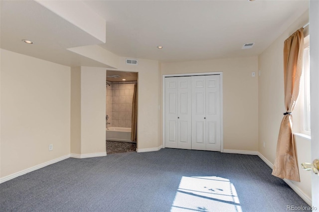 unfurnished bedroom featuring visible vents, baseboards, and dark colored carpet