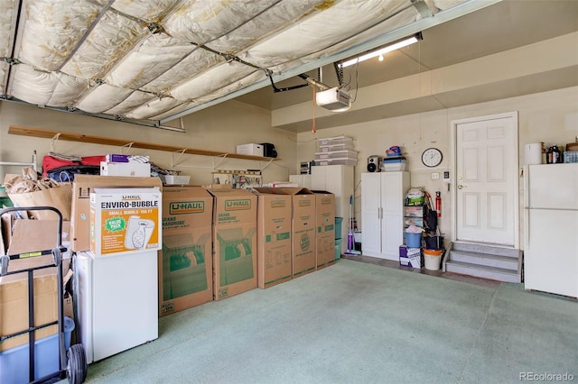 garage featuring freestanding refrigerator and a garage door opener
