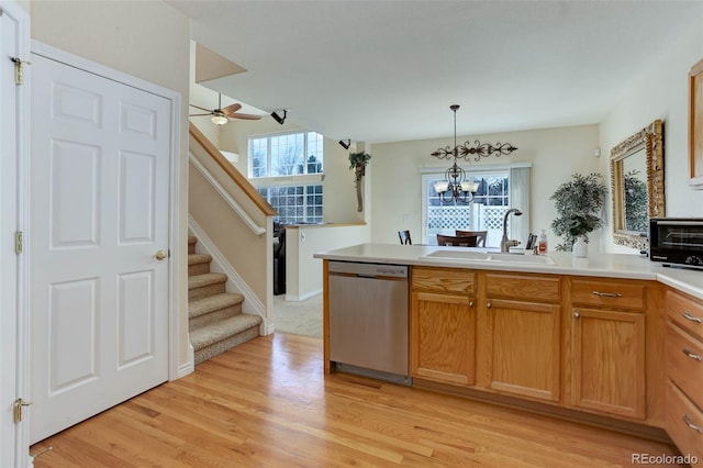 kitchen with a sink, stainless steel dishwasher, plenty of natural light, and a peninsula
