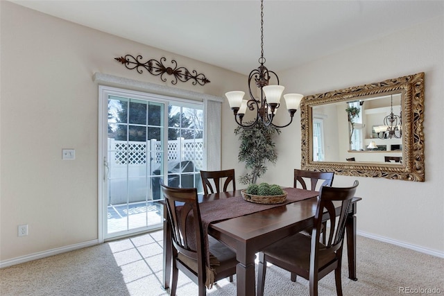 dining area with baseboards, light colored carpet, and an inviting chandelier