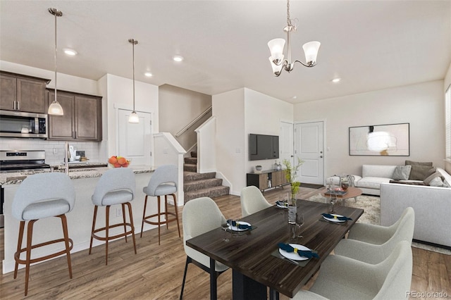 21821 E 7th Ave, Aurora, CO 80018 - dining area featuring light wood-type flooring, stairs, a chandelier, and recessed lighting