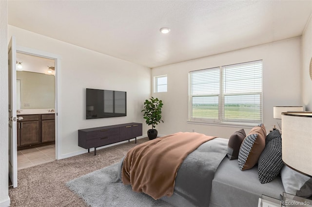 21821 E 7th Ave, Aurora, CO 80018 - bedroom featuring light colored carpet, connected bathroom, and light tile patterned floors