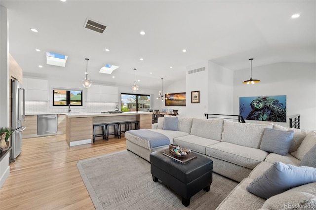 living room with recessed lighting, light wood-type flooring, and visible vents