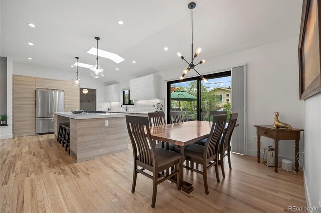 dining area featuring recessed lighting, light wood-type flooring, and lofted ceiling with skylight