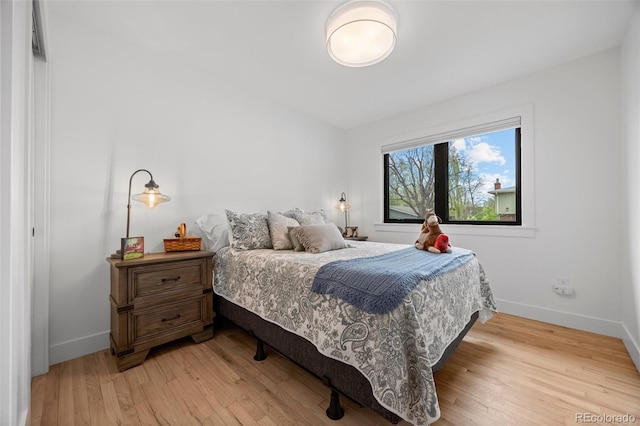 bedroom featuring baseboards and light wood-style flooring