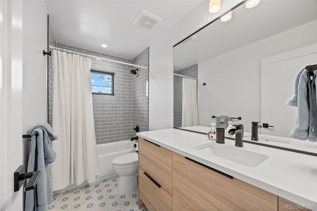 full bathroom featuring toilet, tile patterned floors, shower / bath combination with curtain, and vanity