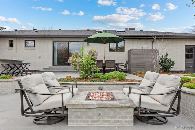 exterior space featuring an outdoor living space with a fire pit, a patio, and brick siding