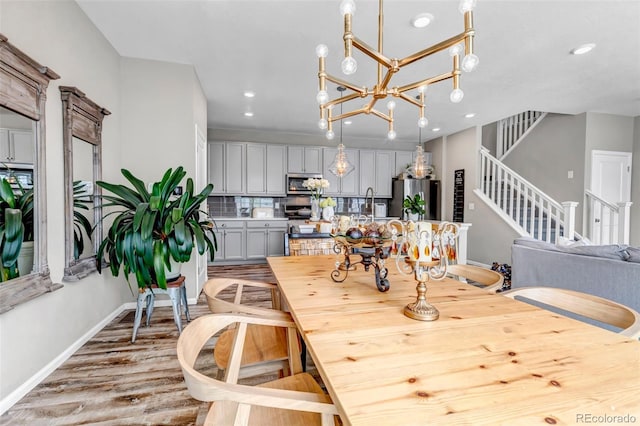 3778 Happyheart Way, Castle Rock, CO 80109 - dining room with baseboards, light wood-type flooring, recessed lighting, stairway, and a chandelier