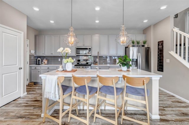 3778 Happyheart Way, Castle Rock, CO 80109 - kitchen featuring appliances with stainless steel finishes, light wood finished floors, light countertops, tasteful backsplash, and recessed lighting