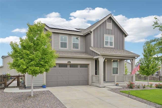 12854 Clearview St, Firestone, CO 80504 - view of front of property featuring covered porch, board and batten siding, a garage, roof mounted solar panels, and driveway