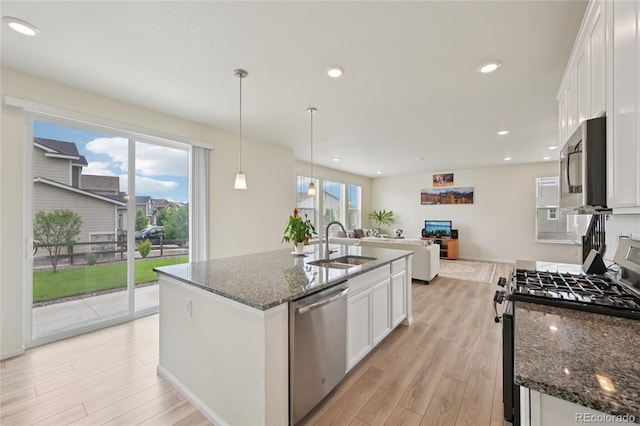 12854 Clearview St, Firestone, CO 80504 - kitchen with stainless steel appliances, light wood finished floors, white cabinets, dark stone counters, and recessed lighting