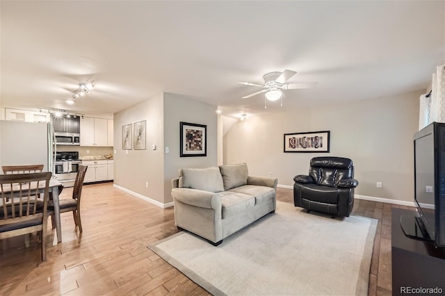 living room with light wood-type flooring and ceiling fan